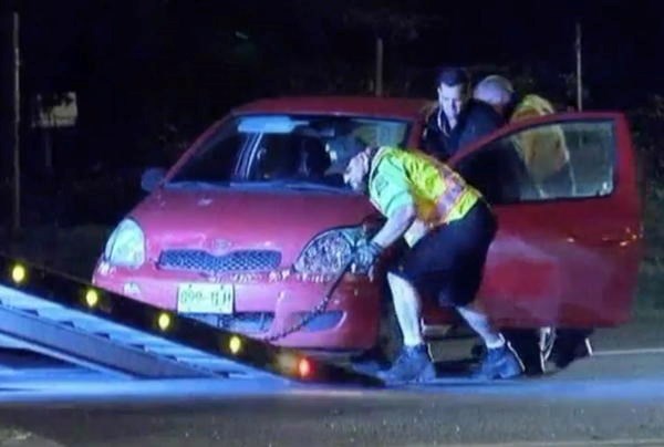 A car is pushed onto a flat-bed truck after it was checked by a hazmat crew at Sooke Road and Veterans Memorial Parkway on Wednesday night.