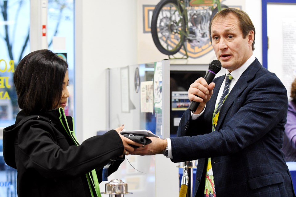 Winning bid: Joy Lewis of Seattle picks up her goods from Mark Madryga during the 20th annual Tie Day fundraiser at Royal City Jewellers. It’s the final year for the fundraiser, which raises money for the food bank by auctioning off ties and memorabilia from celebrities.