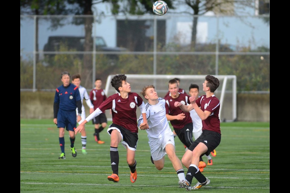 Burnaby North’s Rodrigo Lopez, at left, Dominik Svorinic and Brad Bodnar surround Dr. Charles Best’s Josh Milligan in a battle for the ball during the final round-robin game at last week’s AAA provincial soccer championships, hosted at Burnaby Lake West complex