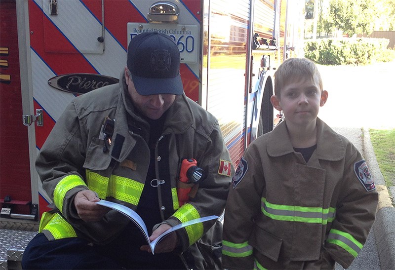 Nathan McTaggart, author of Santa and his Super Hero, with a firefighter.