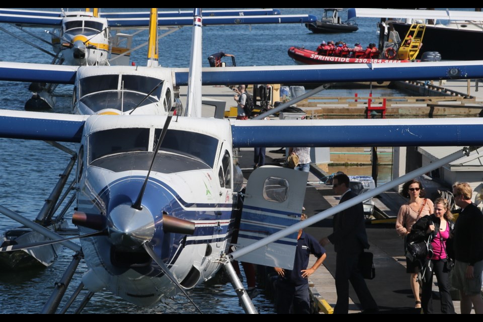 Passengers catch their float plane as a whale watching boat leaves the Inner Harbour on a hot and sunny morning.