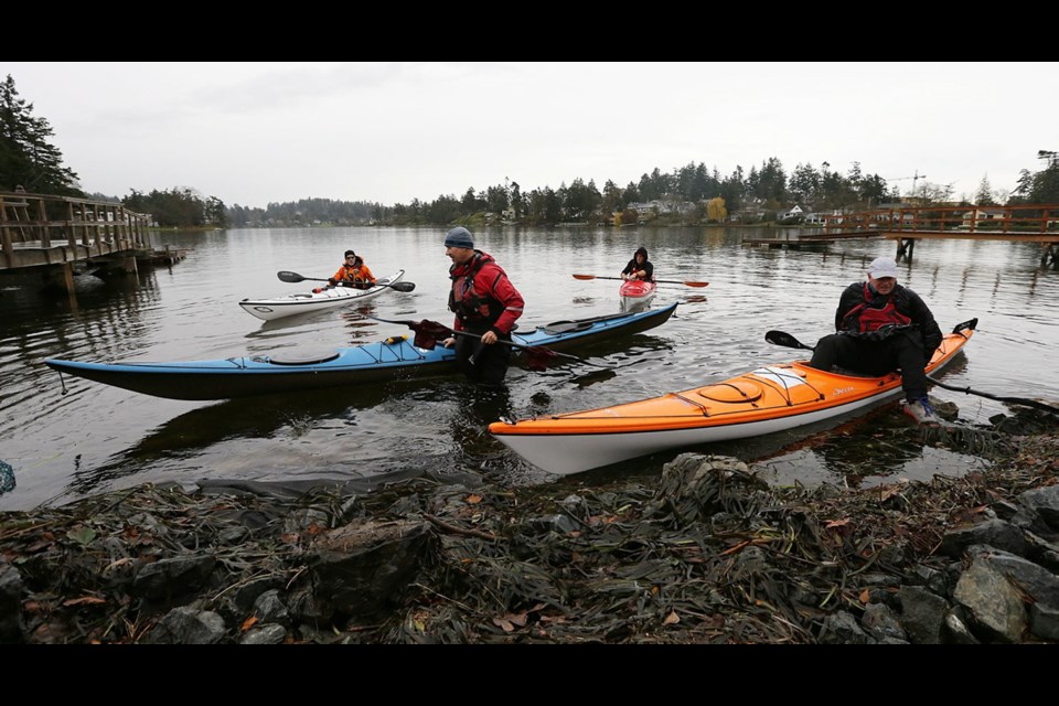 Tanner Ockenden (red), Mark Bitz (white), Gary Dorn (blue) and Brian Henry (orange) prepare to portage their kayaks near Portage Inlet.