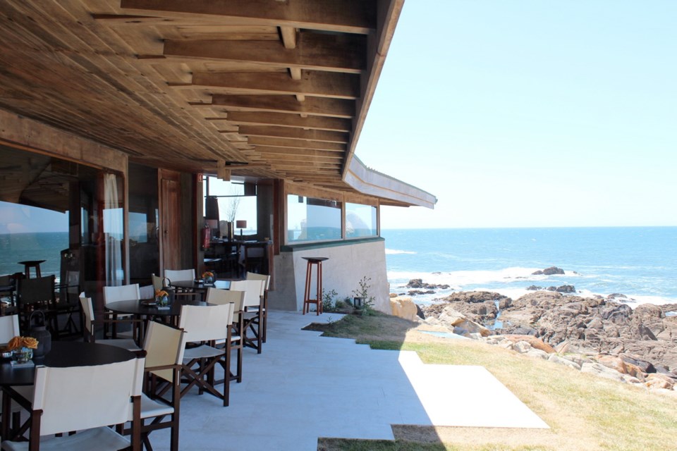 The 40-seat restaurant has windows that disappear into the floor, opening up to concrete patio steps from the rocky shoreline.