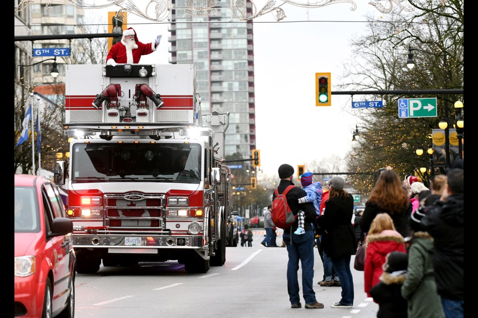 Santa arrives in style atop a New Westminster fire truck.