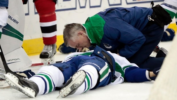 Philip Larsen is attended to by Canucks medical staff.
