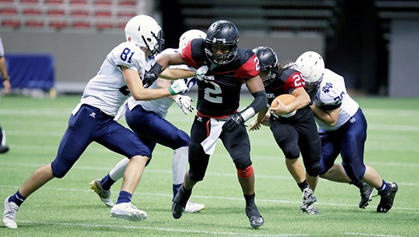 Terry Fox Ravens running back Jeremie Kankolongo, centre, blocks for teammate Matthew Shuen during the AAA high school football provincial championship last Saturday night at BC Place. The Ravens took home the banner after defeating the Notre Dame Jugglers 17-14 in overtime.