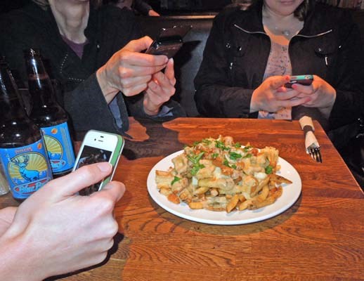 Vancouver foodies take pictures of the chicken and waffle poutine offered at 131 Water Kitchen & Bar as part of the second annual Vancouver Foodster Poutine Challenge.