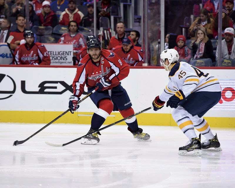 Washington Capitals left wing Alex Ovechkin handles the puck in front of Buffalo Sabres defenceman Brendan Guhle on Monday in Washington.