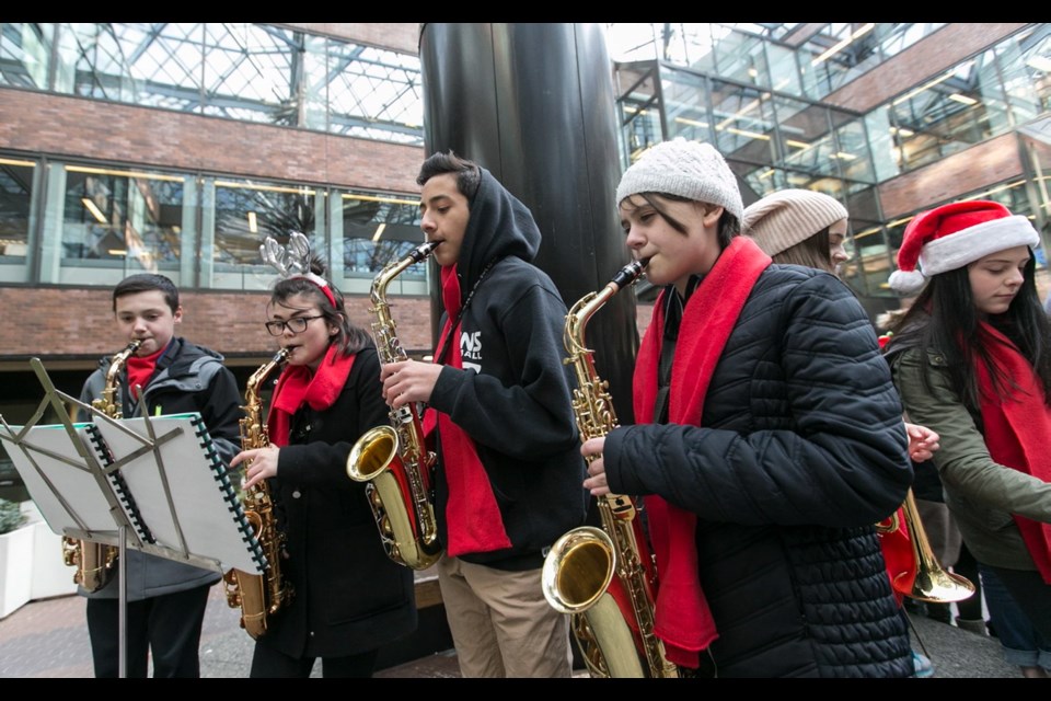 Claremont Secondary School students Gordie Bishop, left, Asya Kiernan, Joseph Reyes and Victoria Miller perform with carollers from two local schools in the weekly Choirs in the Courtyard event at the Greater Victoria Public Library on Thursday.