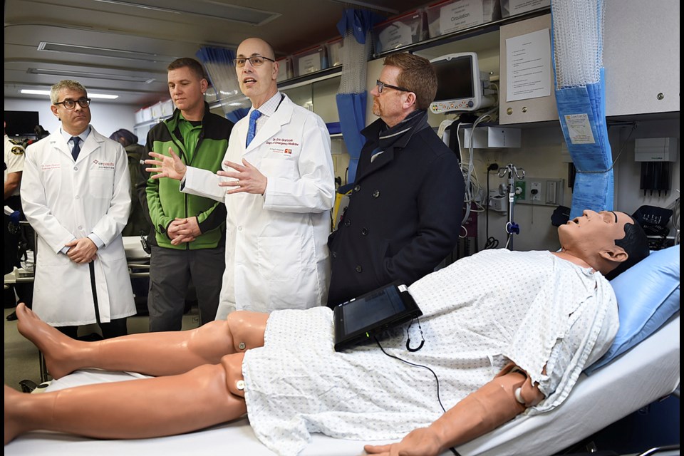 Dr.Eric Grafstein (centre) joined Health Minister Terry Lake (right) Monday at a mobile medical unit at 58 West Hastings that opens Tuesday to respond to the overdose drug crisis concentrated in the Downtown Eastside. Photo Dan Toulgoet