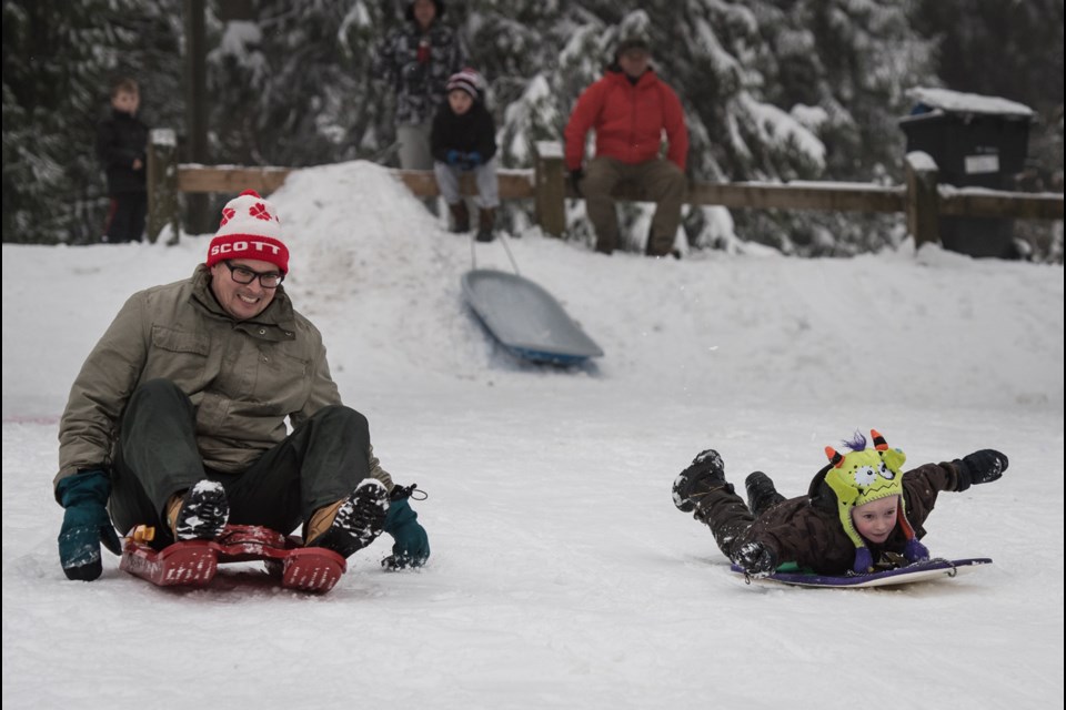 Robert Toth races his son Finley down the hill at Queen's Park on Saturday.