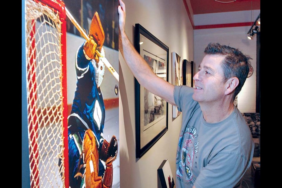 Owner Blair Peters adjusts one of his prized pictures at the recently opened Vintage Sports Images gallery and sales space on Marine Drive in North Vancouver. The gallery features photos on display for browsing and buying. photo Paul McGrath, North Shore News