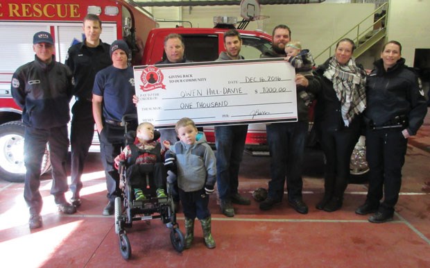 The Delta Firefighters Charitable Society recently presented a cheque for a $1,000 to Owen Hill-Davie to go towards the purchase of a wheelchair accessible van. Owen was recently featured by the Optimist as his family continues to fundraise for the van. From left: Aaron Kokotialo, Eric Butler, Eric Wilson, John Burr, Jarrod Burr (all Delta Fire Department), Peter, Stephanie, Nora, Owen and Oliver Hill-Davie, cousin Nathan and Jody Waldron (Delta Police Department).