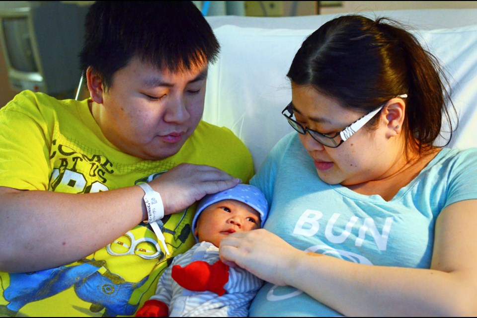 Kevin Tam and Lena Zheng pose with their new baby boy, Maximus Tam, the first baby born at Burnaby Hospital this year.