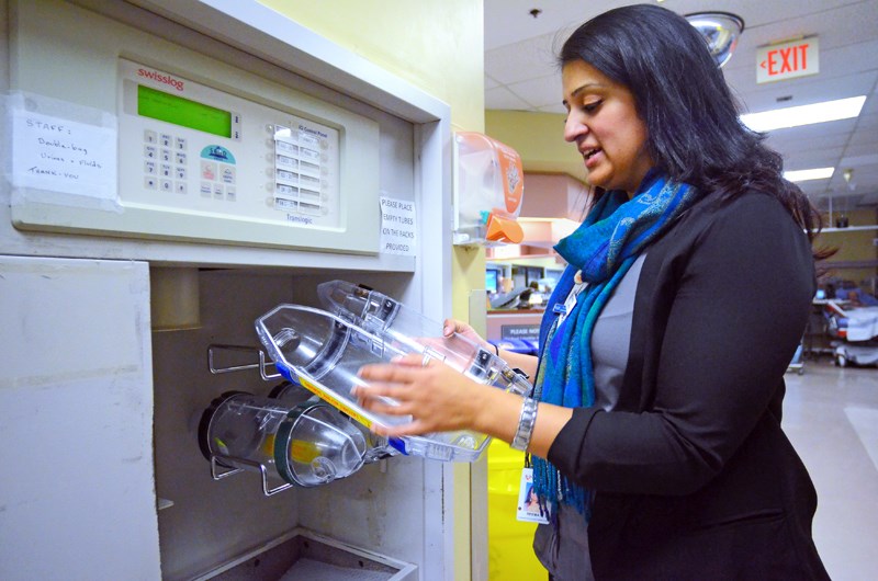 RCH site operations manager Reema Prihar opens one of the plastic containers used to hold items delivered around the hospital via its current, outdated pneumatic tube system.