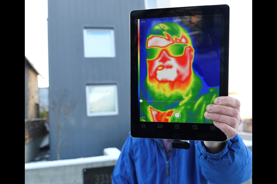 Chris Higgins, a green building planner for the City of Vancouver, demonstrates how a thermal imaging camera works. Photo Dan Toulgoet