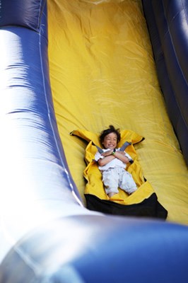 Six year-old Cole Priestman rips down the inflatable slide provided by Provident Security at Kerrisdale Days on Saturday.