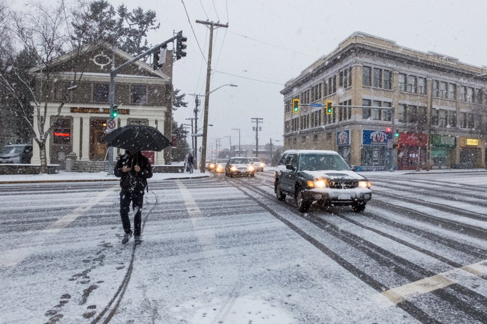 Snow falls at Douglas and Bay streets in Victoria during the morning commute.