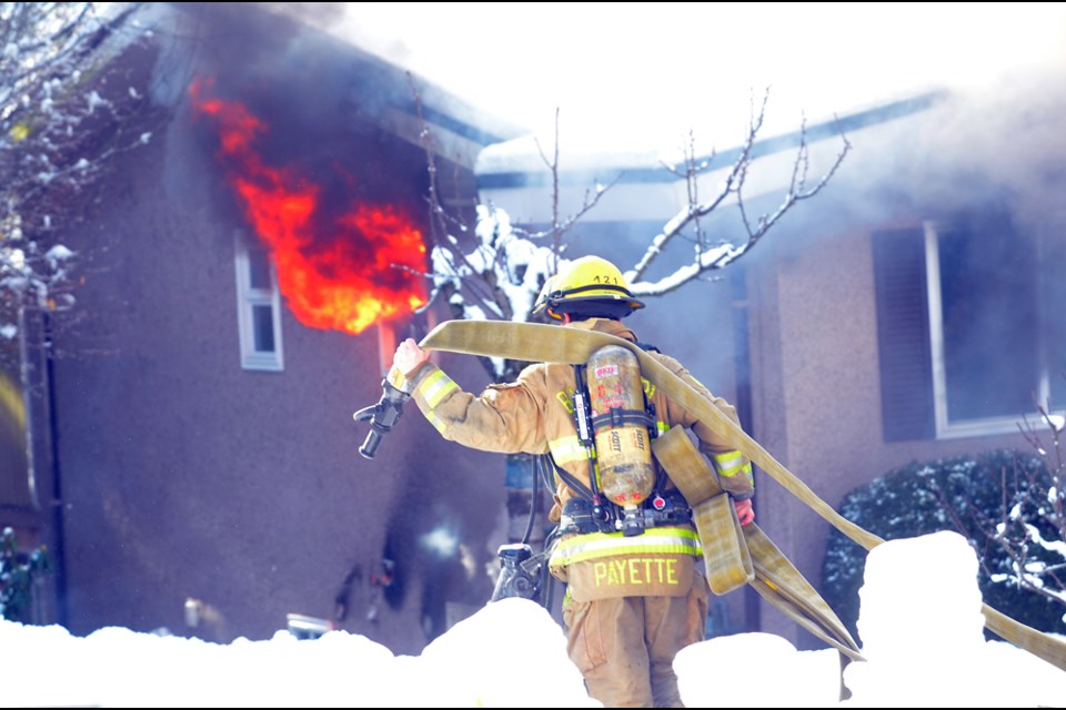 Burnaby firefighters battle a midday house fire on Fielding Court Monday.