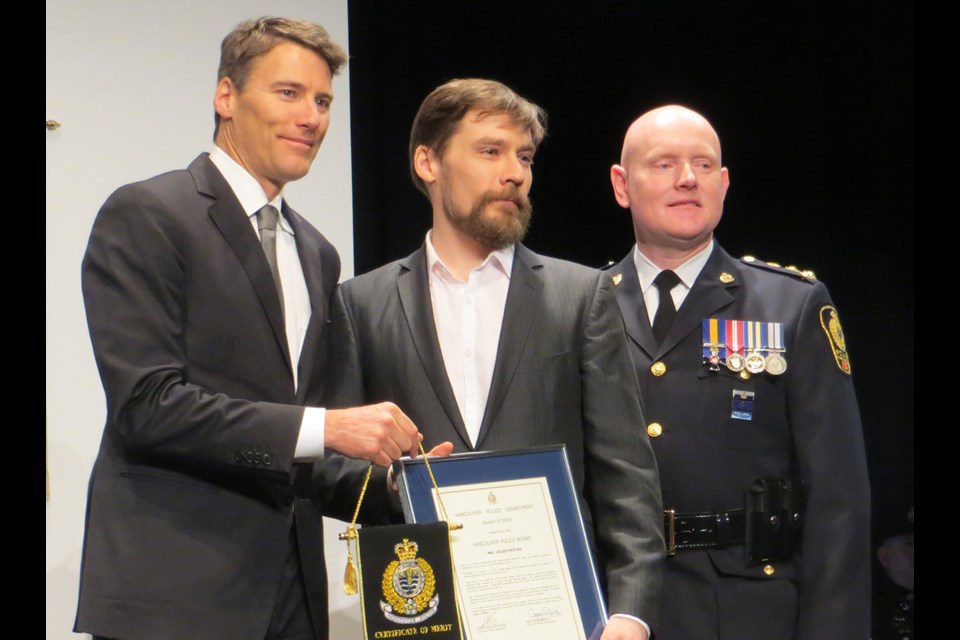 Caleb Hystad receives his award of merit from Vancouver Mayor Gregor Robertson and VPD Chief Constable Adam Palmer.
