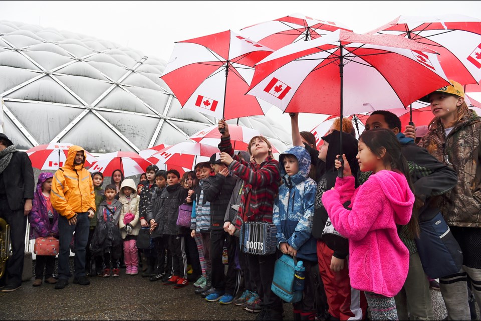 School children from the Nootka elementary sing before a Canadian flag is raised for the first time at Bloedel Conservatory Plaza on Feb. 15, 2017. Photo Dan Toulgoet