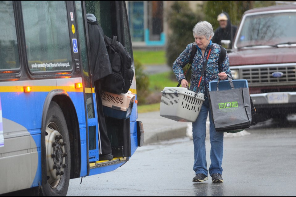 Stratford House residents board a bus with their pets and a few belongings Wednesday, after morning blaze destroyed their building at a B.C. Housing complex on Pandora Street.