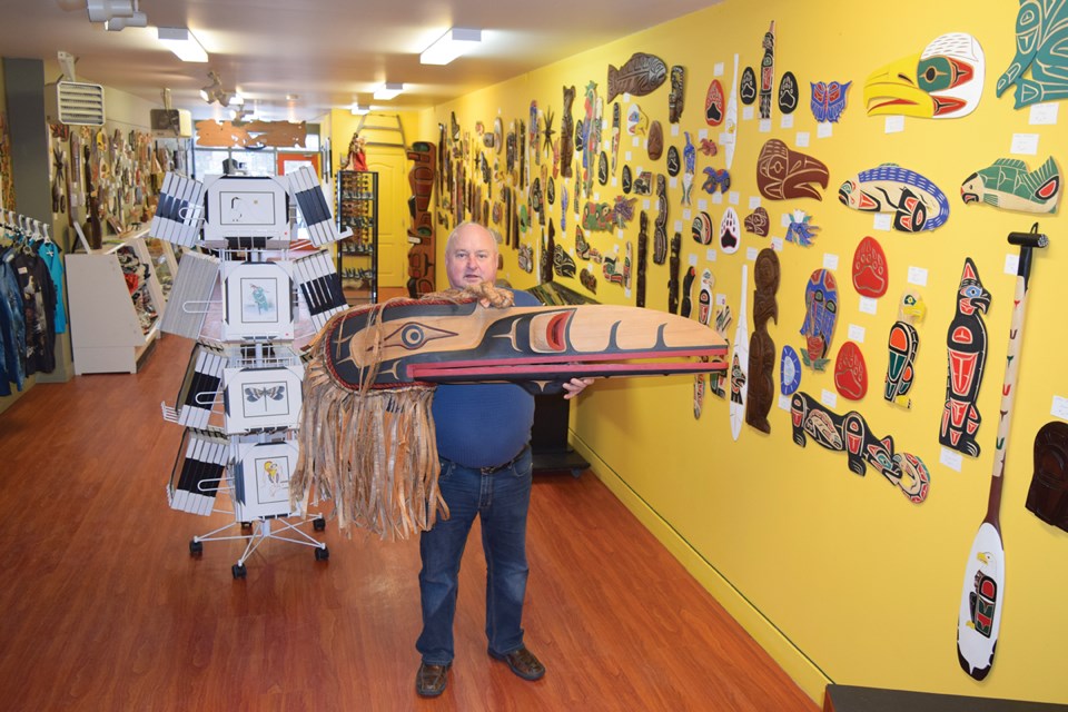 Murray McCorriston, owner of the Squamish Native Art Store, holds a raven mask that was carved by Vince Shaughnessy, First Nations master carver. The piece sells for $6,000 in McCorriston’s Cleveland Avenue store.