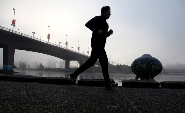 A man jogs on the Yaletown seawall near the Cambie Street bridge.