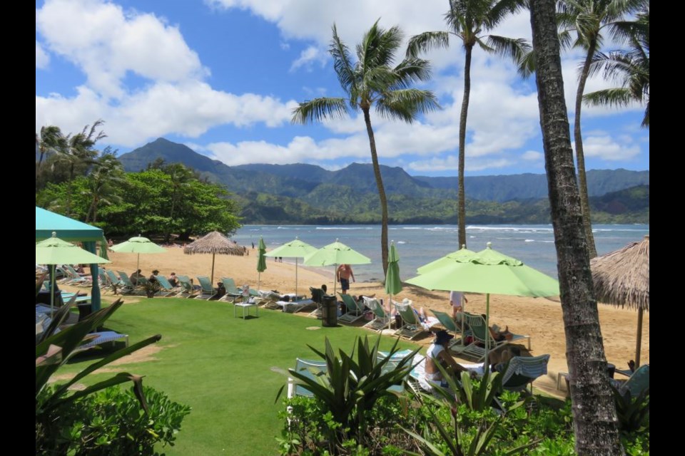 Mint green umbrellas dot the beachfront of the St. Regis Princeville Resort on the Island of Kauai. Photo Sandra Thomas