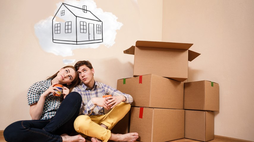 Young couple first time home buyers dreaming with boxes