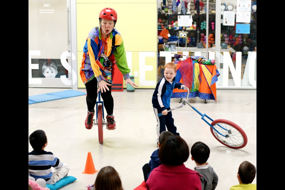Sand Northrup gets some assistance from four-year-old Charlie Preston during her One Woman Circus show at River Market.