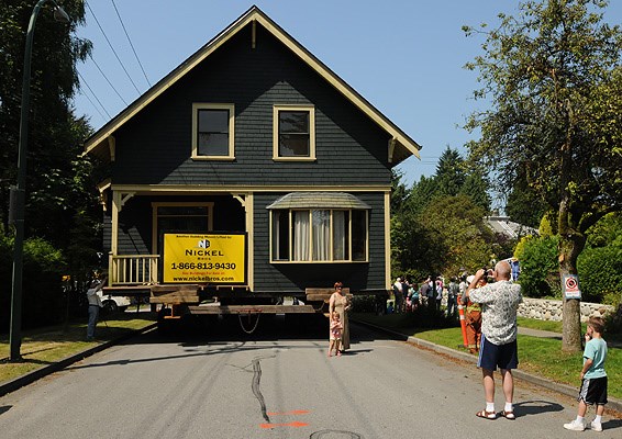 Neighbours watch as 97-year-old house on 3725 West 37th Ave. is moved to the Fraser River for eventual transport by barge to Vancouver Island.