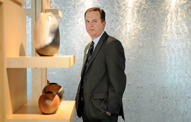 Garry Hayes, manager at the North Shore credit union on West Broadway and Yew. Pottery on display in the foreground by local artist Suzanne Starr.