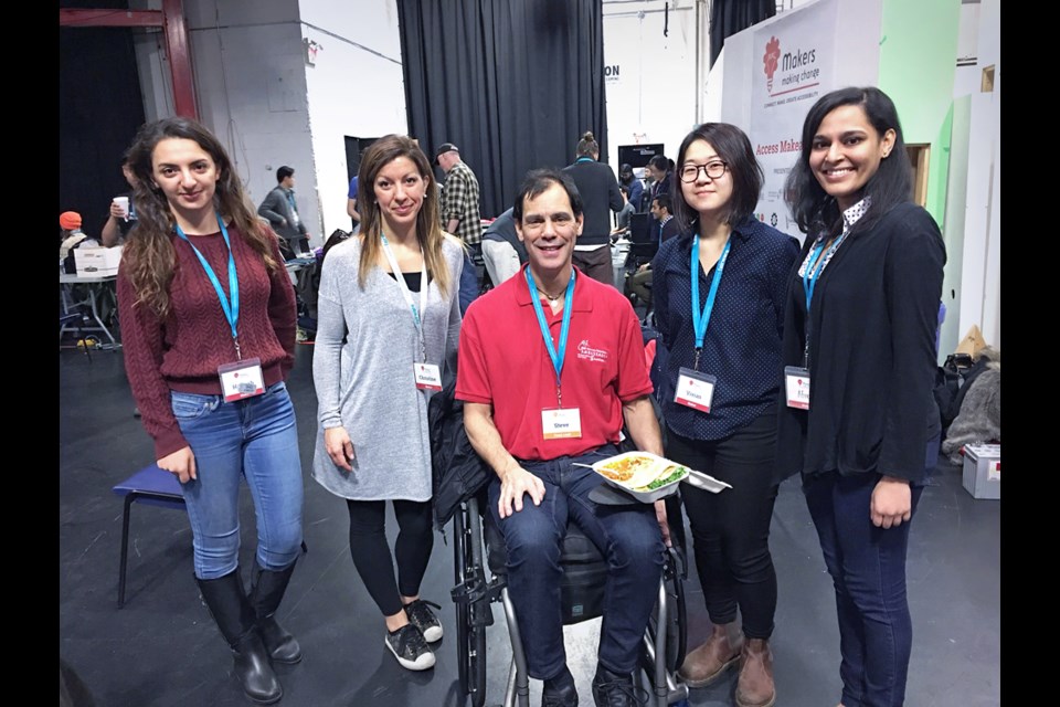 Burnaby resident Steve Grout poses with ‘Team Steve,’ a group of SFU and UBC engineering students who helped design a popcorn/food holder for his wheelchair during the Neil Squire Society's Access Makeathon.