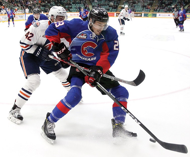 Aaron Boyd of the Cougars fights off the check of Kamloops Blazers defenceman Ondrej Vala during Saturday's WHL game at CN Centre. The Cougars scored five goals in the second period on the way to a 6-1 win.