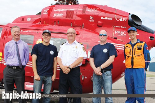 The STARS helicopter on the tarmac at Virden’s airport, Monday, Jun. 12 marks the kick-off for “Rescue on the Island” fundraiser which Wallace District Fire Department Chief Brad Yochim will take part in; (l-r) Virden Mayor Jeff McConnell, firefighter Joseph Pappel, Chief Brad Yochim, firefighter Bruce Brading, and STARS pilot Dave Harris.