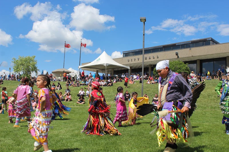 A group of dancers performs in front of City Hall for National Indigenous Day.