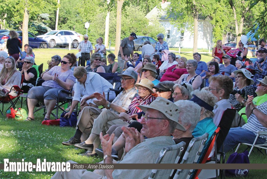 The crowd applauds Prairie Joe, enjoying a perfect summer evening. In the background, Prairie West Recreation, sponsoring the Thursday concerts, takes silver donations, where people enter a draw and ice cream is given to the many children who came along.