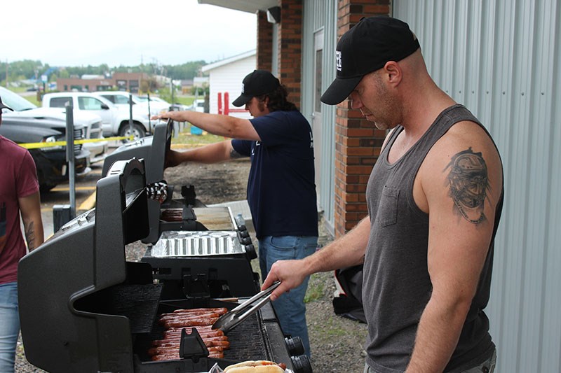 Union member Scott Clements (right) cooks some hotdogs outside the United Steelworkers Local 6166 ha