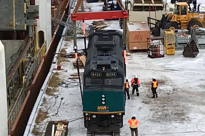 A Via Rail train being loaded onto a ship for transport out of Churchill