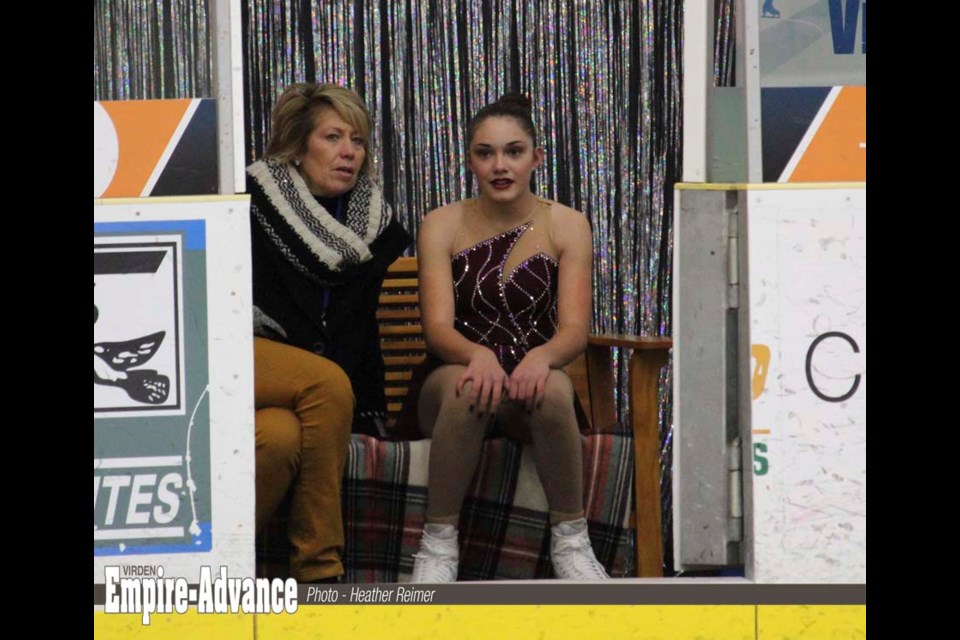 Coach Patty Hole of Skate Virden waits with skater Abby Collen on the “kiss and cry” bench for the judges to announce her marks.