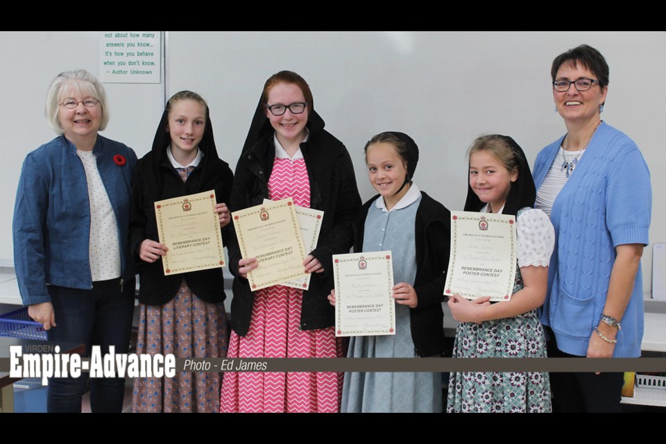 Students are holding up their awards certificates; several of the students were multiple winners; from (l to r) Margaret James RCL, Christina Waldner (Gr.6), Sarena Waldner (Gr.8), Kayley Waldner (Gr. 3), Aleah Waldner (Gr. 5) and Plainview Colony school principal Michele Shaw.