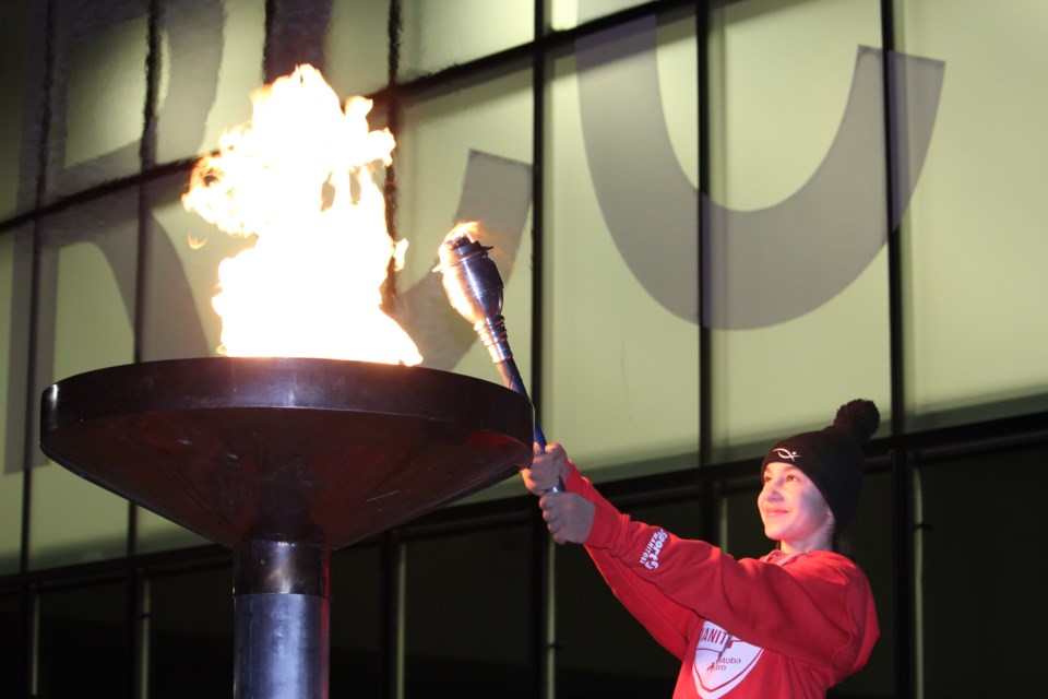 Thompson figure skater Megan Szabo lights the cauldron outside of the Thompson Regional Community Ce