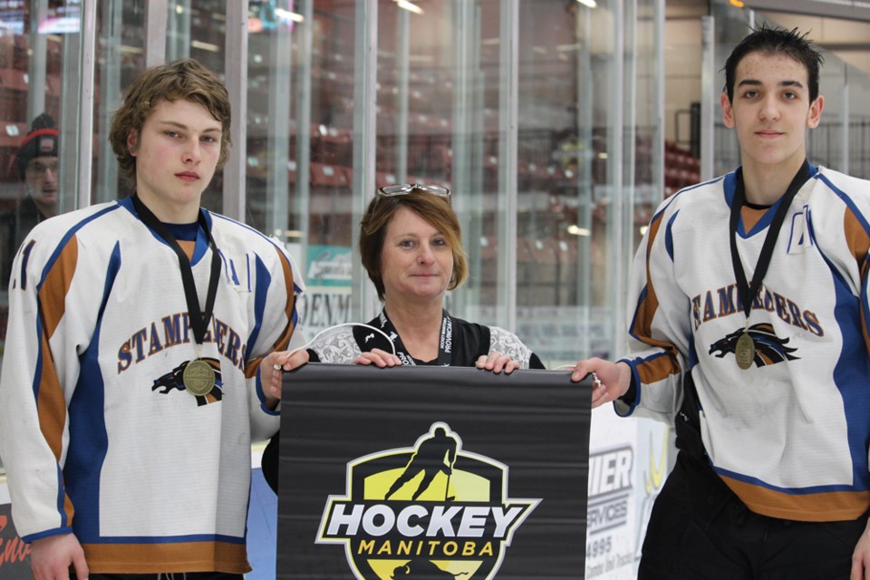 Manager of Virden Bantam Rural A Provincials, Fran Lansing presents the winners of the gold medal event, Swan Valley Stampeders, with the Hockey Manitoba championship banner, Sunday, Mar. 11.