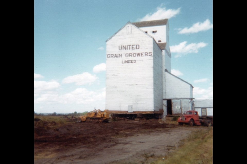 A 28,000-bushel grain elevator at Rossendale, 18 miles southwest of Portage la Prairie, was built in 1916 by the Grain Growers’ Grain Company, predecessor of United Grain Growers. Over the years, two annexes were built to increase its capacity, a 25,000-bushel balloon annex in 1951 (demolished around 1970) and a 30,000-bushel crib annex in 1954. Closed in 1975, the elevator was demolished three years later while the crib annex was moved to the Baker Hutterite Colony. Along the way, the annex had to be hauled up a 70-foot hill under muddy conditions. This photo was one of several taken by Eddie Maendel, now living at the Airport Hutterite Colony, who helped with the move. The annex is still in use.