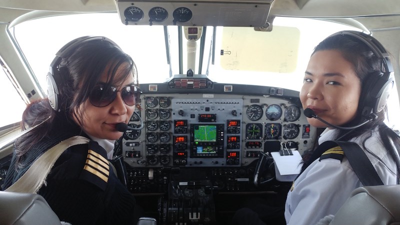 Robyn Shlachetka, left, and Raven Beardy, right, pose for a photo during their history-making flight