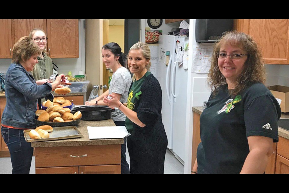 Reston teacher Sadie Riendeau (second from right) and staff prepare for BBQ fundraiser in support of the Humboldt Broncos.