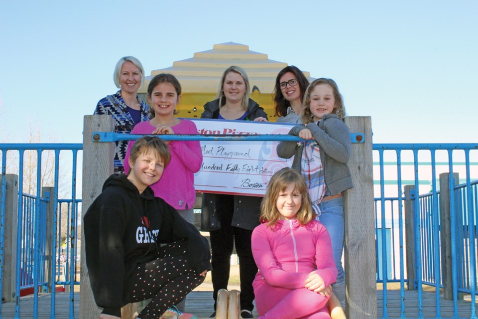 The play structure at Mary Montgomery School is being replaced after three years of fundraising by the parents committee. A new $63,000 structure will be set up here next week. (back row l-r) Playground committee members Cherilynn Pizzey, Jillian Irvine and Brooke Williams donating $558 from Boston Pizza, (middle row) students Sadie Brown and Mya Irvine, (front row) students Aiden Stendall and Kaitlyn Cox.