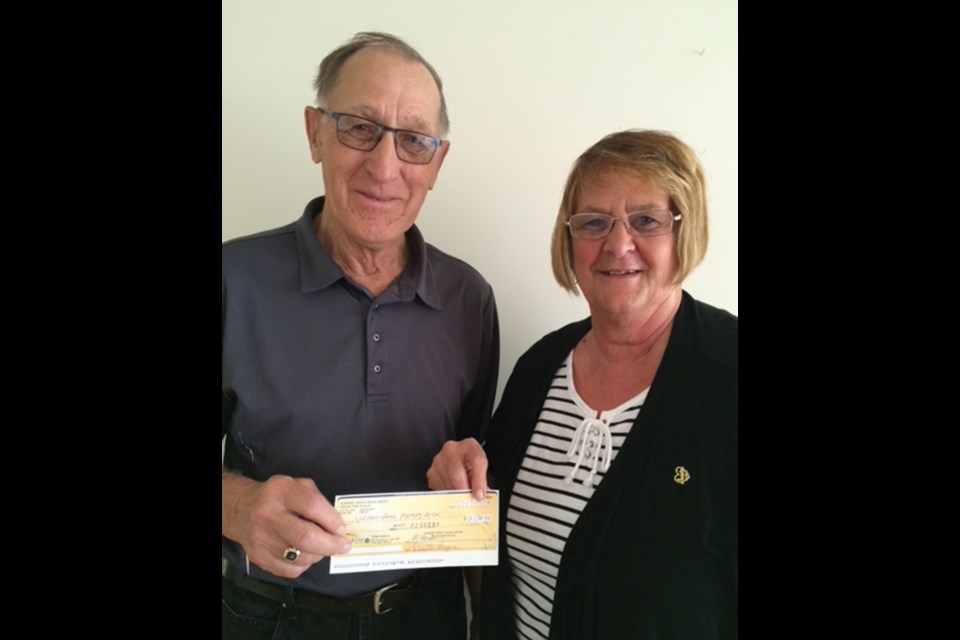 Keith Wadham of the Virden & Area Memory Tree accepts a donation cheque from Sandra Wooldridge, in memory of her husband Murray.