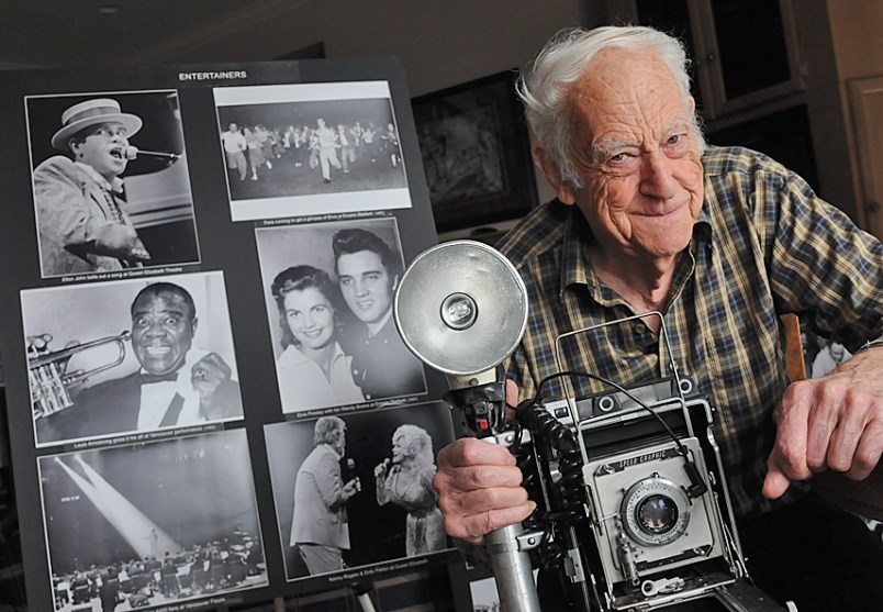 Acclaimed photojournalist Ralph Bower poses with some of his pics, and a Speed Graphic 4x5 camera, in the lead up to an exhibition of his work that’ll be on display at City of North Vancouver municipal hall starting Friday.
